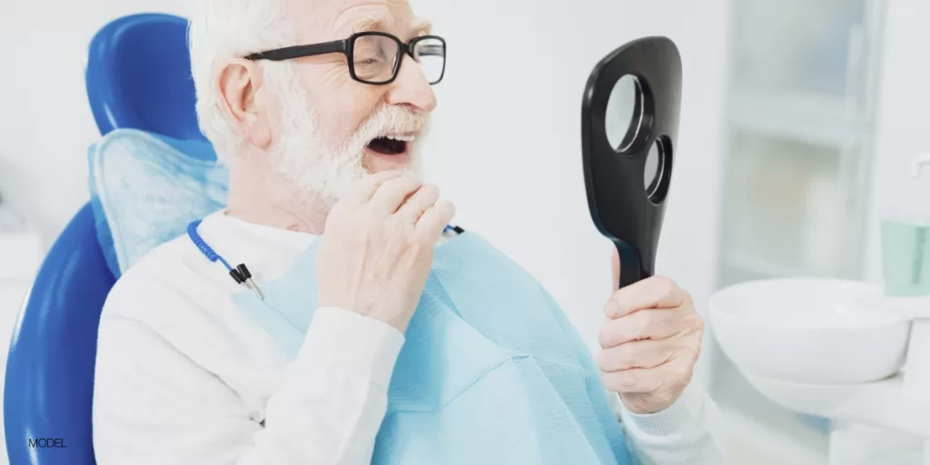 Senior looking at his dental implants post surgery